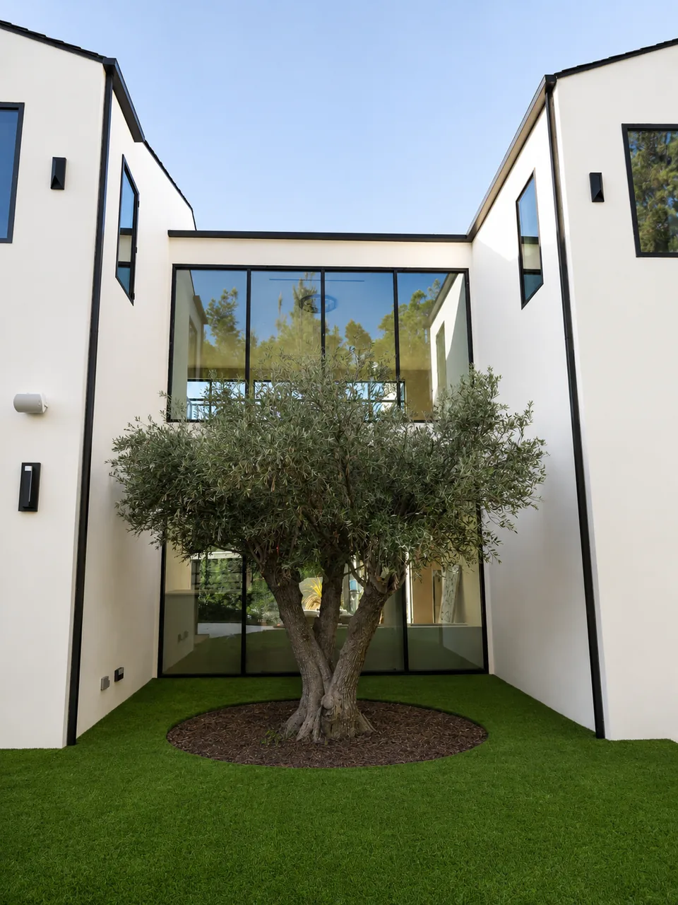 Two-storey corner glazing framing a courtyard