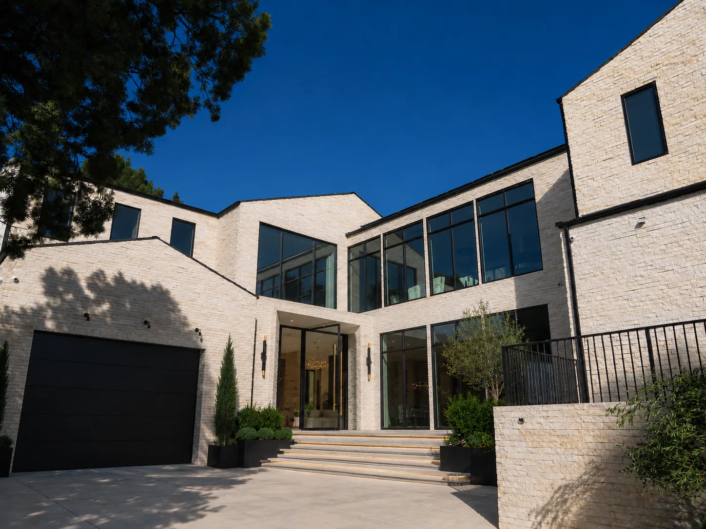 Stone-clad contemporary residence with tall black-framed windows at the entry