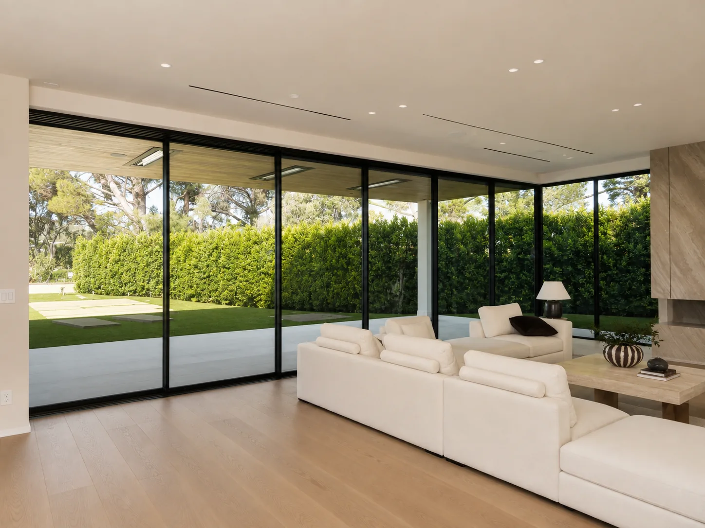 Living room with a full-height glazed wall opening onto a lawn