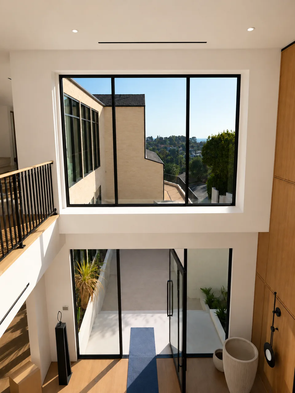 Double-height stairwell glazing lit from above